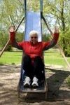 Old woman gets her jollies in playground.jpg